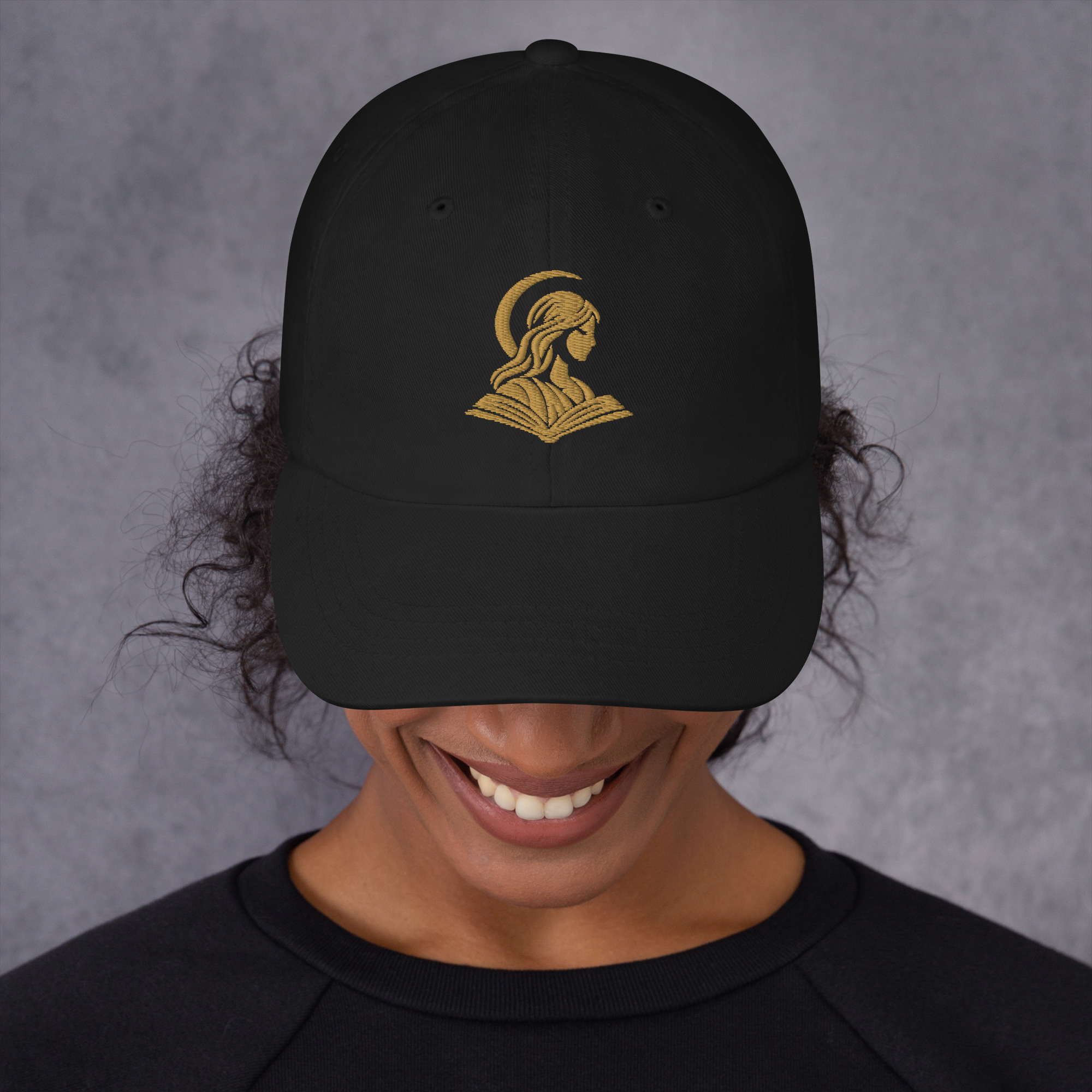 Gorra negra de La Memoria Olvidada con bordado dorado: maqueta oficial de Printful.